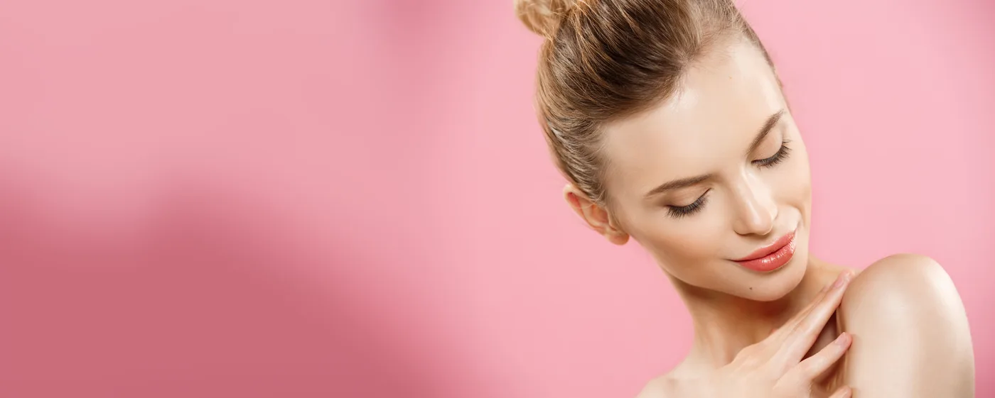 Modelka z naturalną cerą na różowym tle